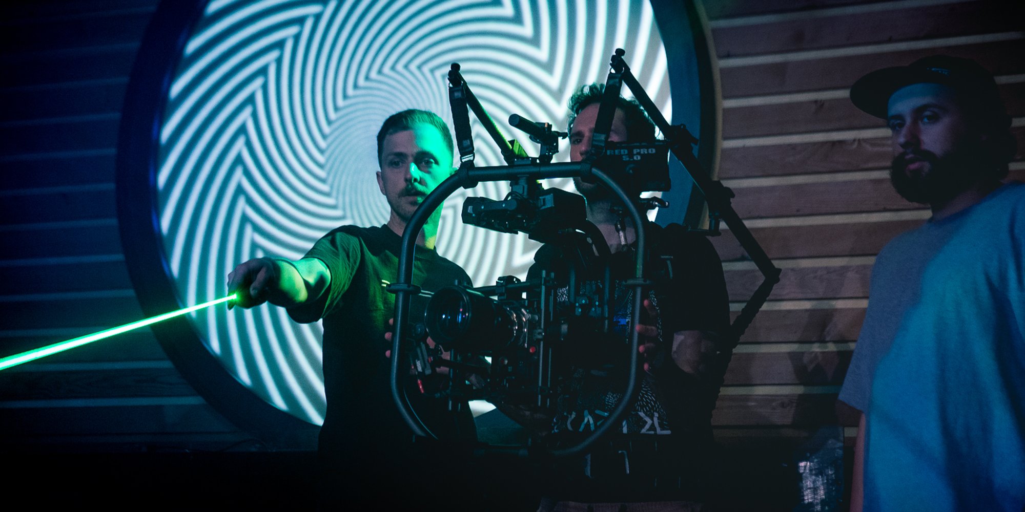 Gaffer Kyle Pigeau with a lazer pointer, checking the frame for rogue pieces of furniture. BTS by Tal Vardi.